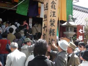釈迦堂前に建つ回向柱に触れる参拝者